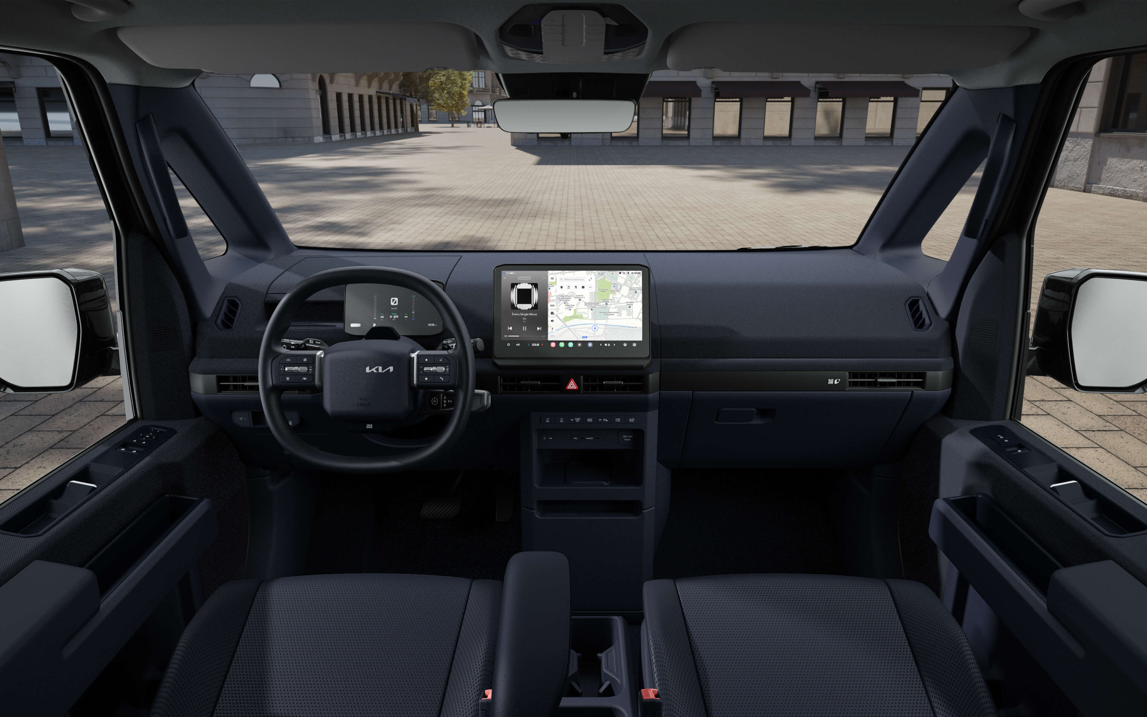 Vista frontal del interior del Kia PV5 Mercancías que destaca la amplia visibilidad frontal para una conducción segura, carga mediante USB-C y asientos duraderos para el uso diario.