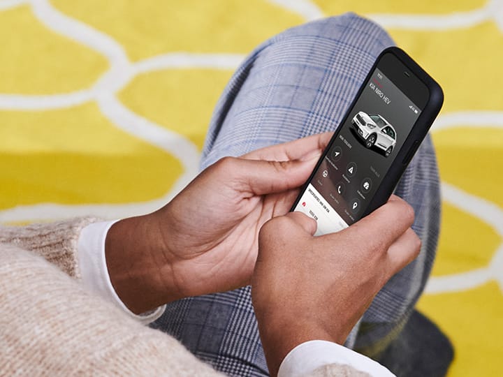 Man houdt smartphone met de MyKia-app vast