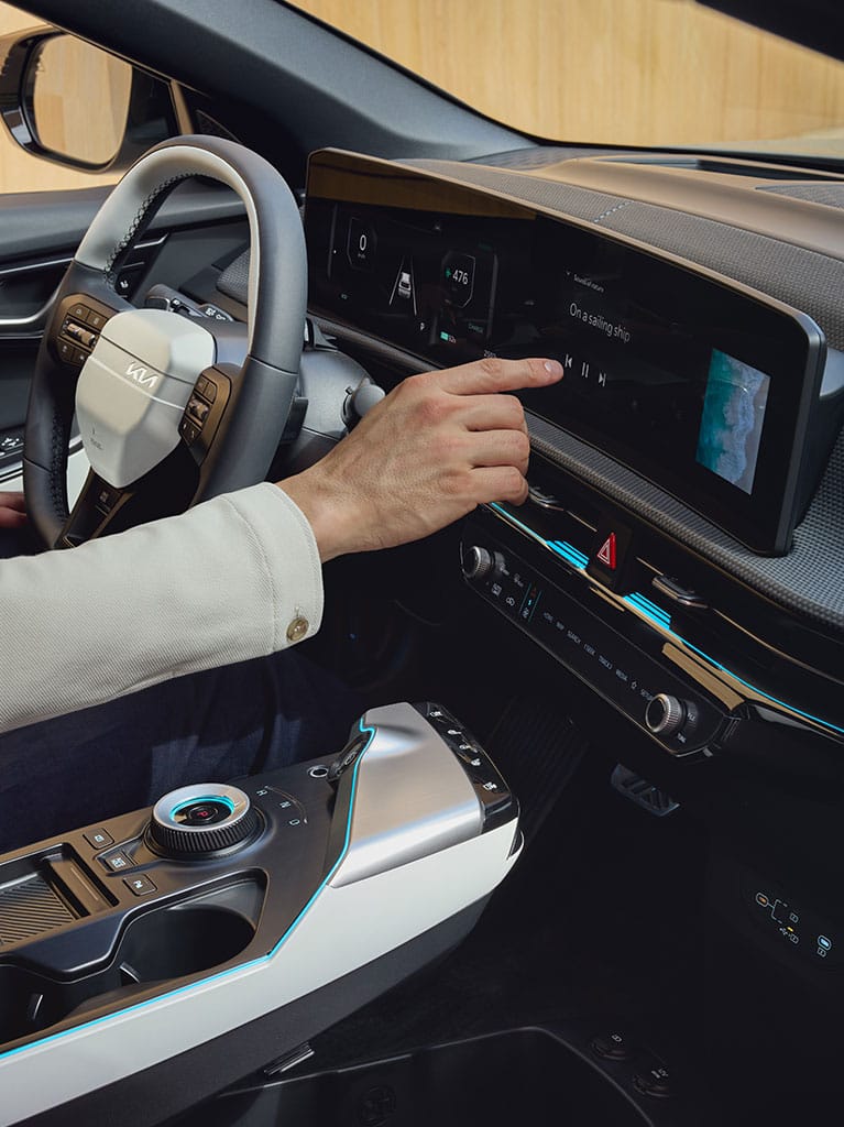 Inside a Kia EV6, a man operates the touchscreen